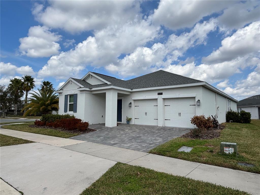 A single-story white house with a two-car garage and a paved driveway — 4697 FAIRY TALE CIRCLE, KISSIMMEE, FL