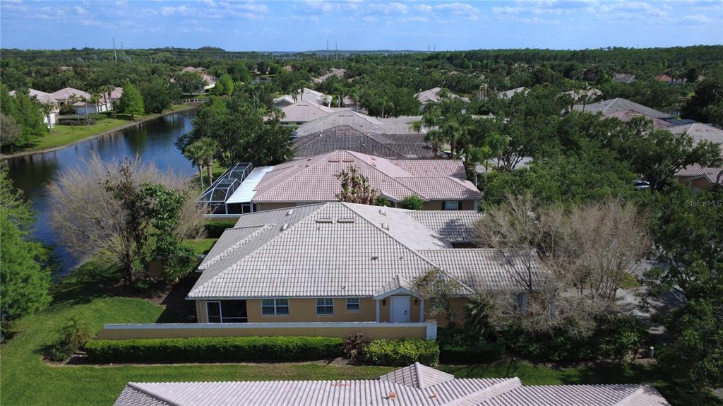 An aerial view shows a tan house with a tiled roof next to a canal — 11801 FAN TAIL LANE, ORLANDO, FL