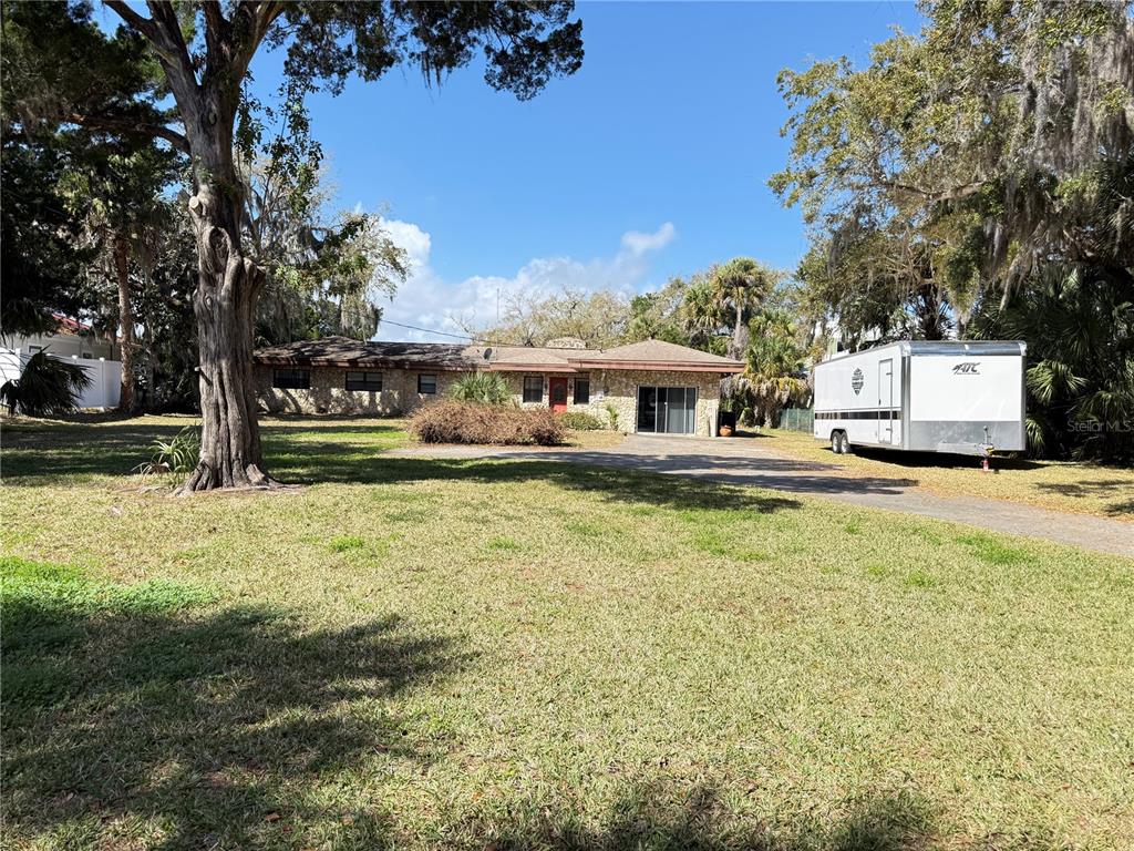 A single-story stone house with a large lawn and a trailer parked in the driveway — 508 S INDIAN RIVER ROAD, NEW SMYRNA BEACH, FL