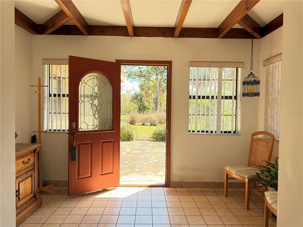 An entryway with tiled floors, a wooden ceiling, and a red front door — 508 S INDIAN RIVER ROAD, NEW SMYRNA BEACH, FL