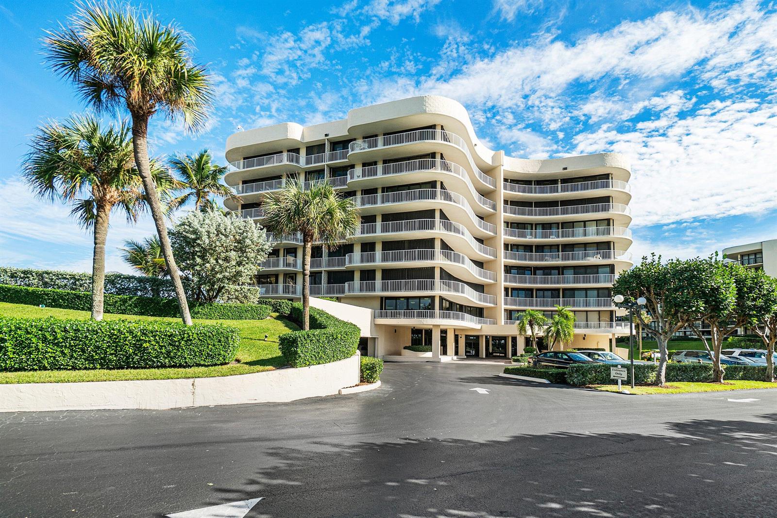 A multi-story residential building with curved balconies and palm trees sits above a paved driveway — 3400 S Ocean Boulevard, Palm Beach FL 33480, PALM BEACH, FL