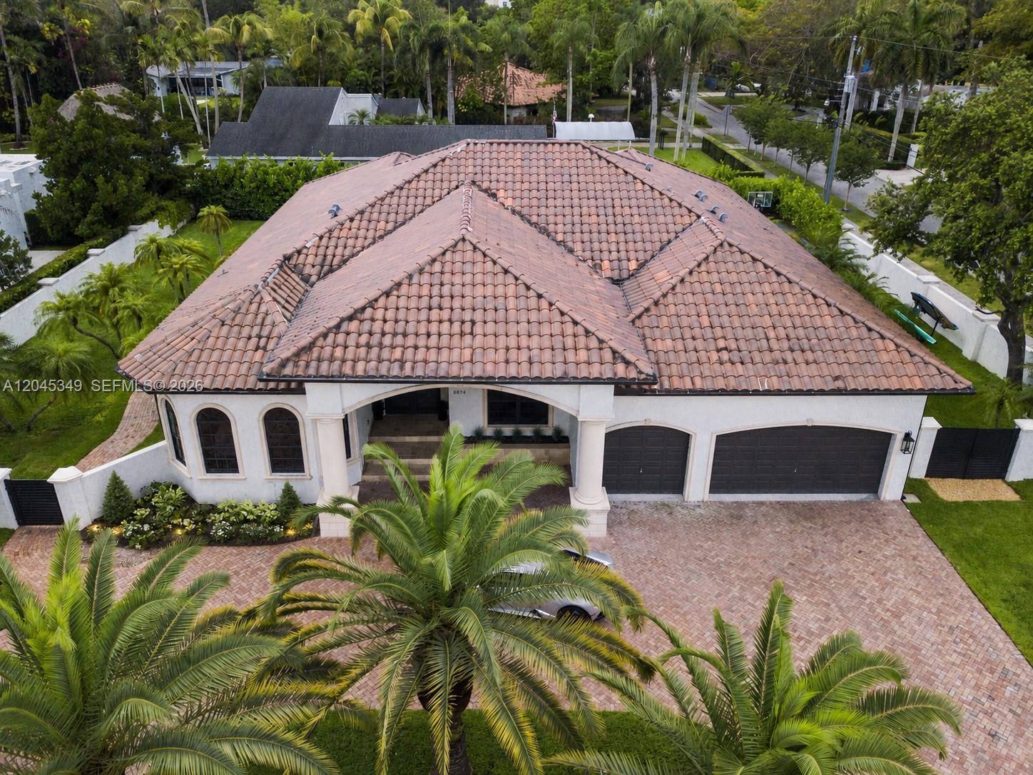 An aerial view shows a single-story house with a tiled roof, palm trees, and driveway — 6874 SW 57th Ter, Miami FL 33143, MIAMI, FL