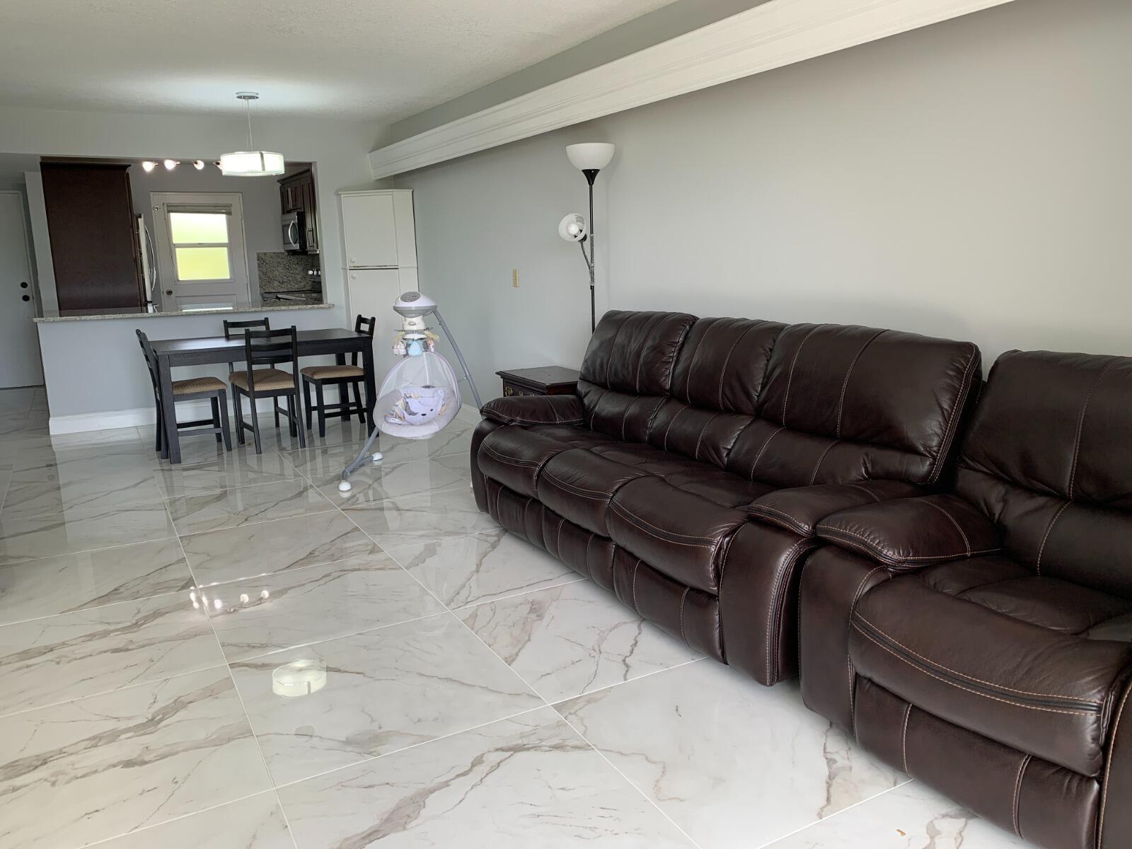 A kitchen features dark wood cabinets, granite countertops, and stainless steel appliances — 5700 NW 2nd Avenue # 311, Boca Raton FL 33487, BOCA RATON, FL