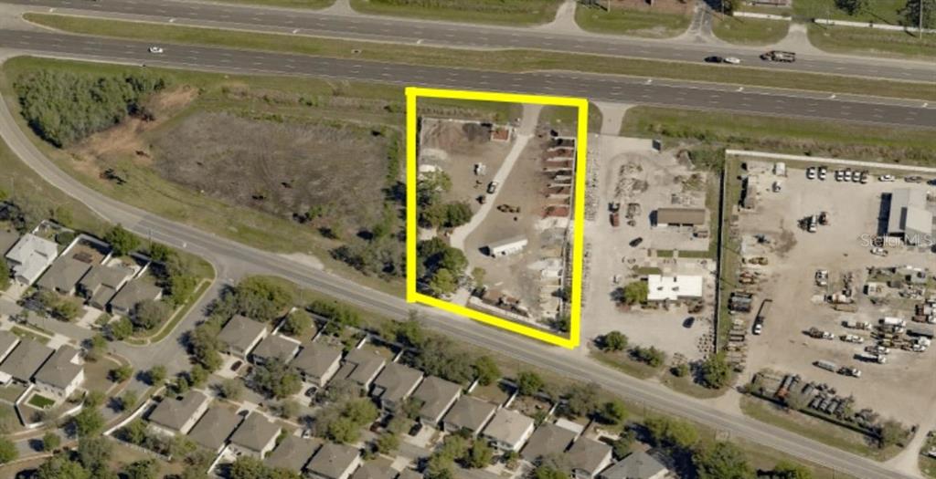 An aerial view shows a rectangular plot of land outlined in yellow near a highway — 14024 STATE ROAD 54, ODESSA, FL