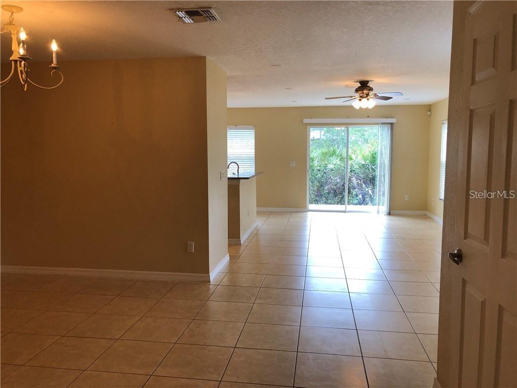 An interior view shows a tiled living area with a ceiling fan and sliding glass doors — 4330 ARISTOCRAT POINT, OVIEDO, FL