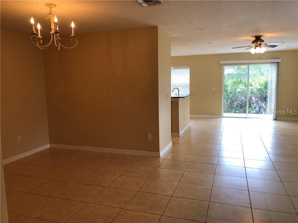 A dining area with a chandelier opens into a living room with tile flooring — 4330 ARISTOCRAT POINT, OVIEDO, FL