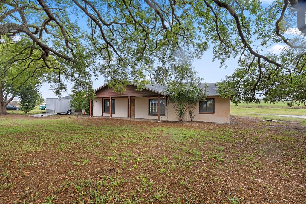 A single-story house with a covered porch sits on a large, tree-shaded grassy lot — 17425 LAKE INGRAM ROAD, WINTER GARDEN, FL