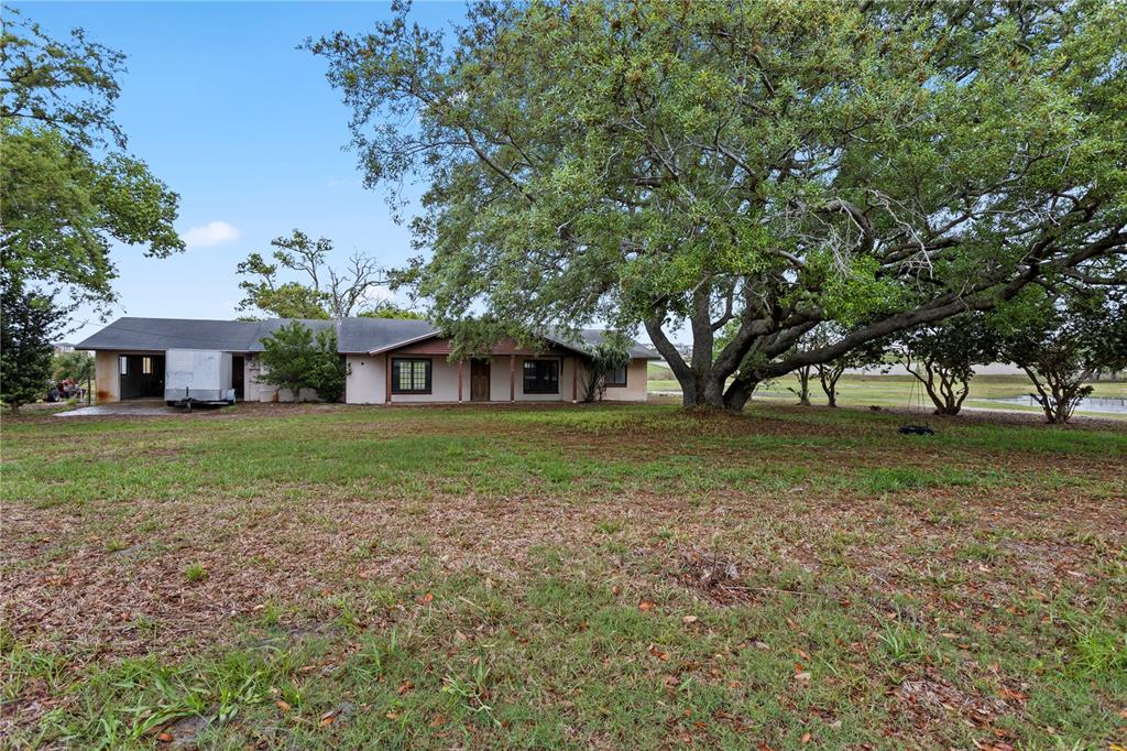 A single-story house with a covered porch and a large oak tree in the yard — 17425 LAKE INGRAM ROAD, WINTER GARDEN, FL