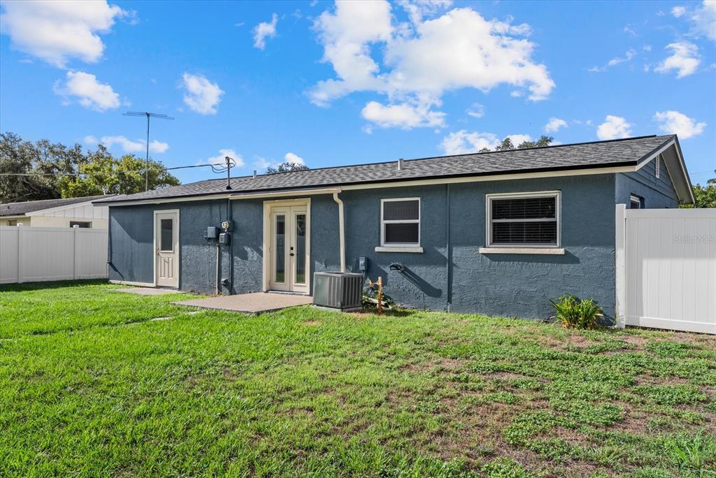 An empty room with white walls, wood-look flooring, a window, and a glass-paneled door — 4915 BELL MEADE DRIVE, SARASOTA, FL