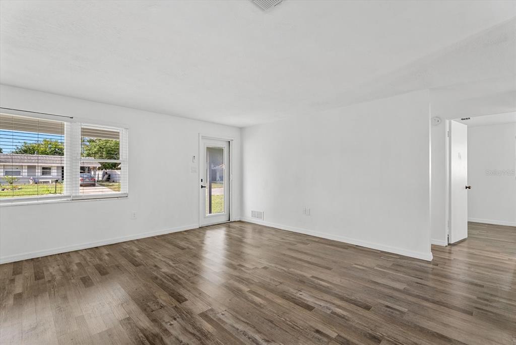 A room with white walls, wood-look flooring, a ceiling fan, and a window with blinds — 4915 BELL MEADE DRIVE, SARASOTA, FL