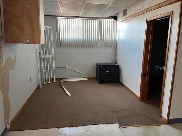 An interior room features brown carpeting, a black safe, and a doorway leading elsewhere — 10802 MAIN STREET UNIT A, THONOTOSASSA, FL
