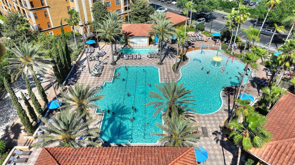 An aerial view shows a large swimming pool complex with palm trees and lounge chairs — 12539 FLORIDAYS RESORT DRIVE UNIT 211D, ORLANDO, FL