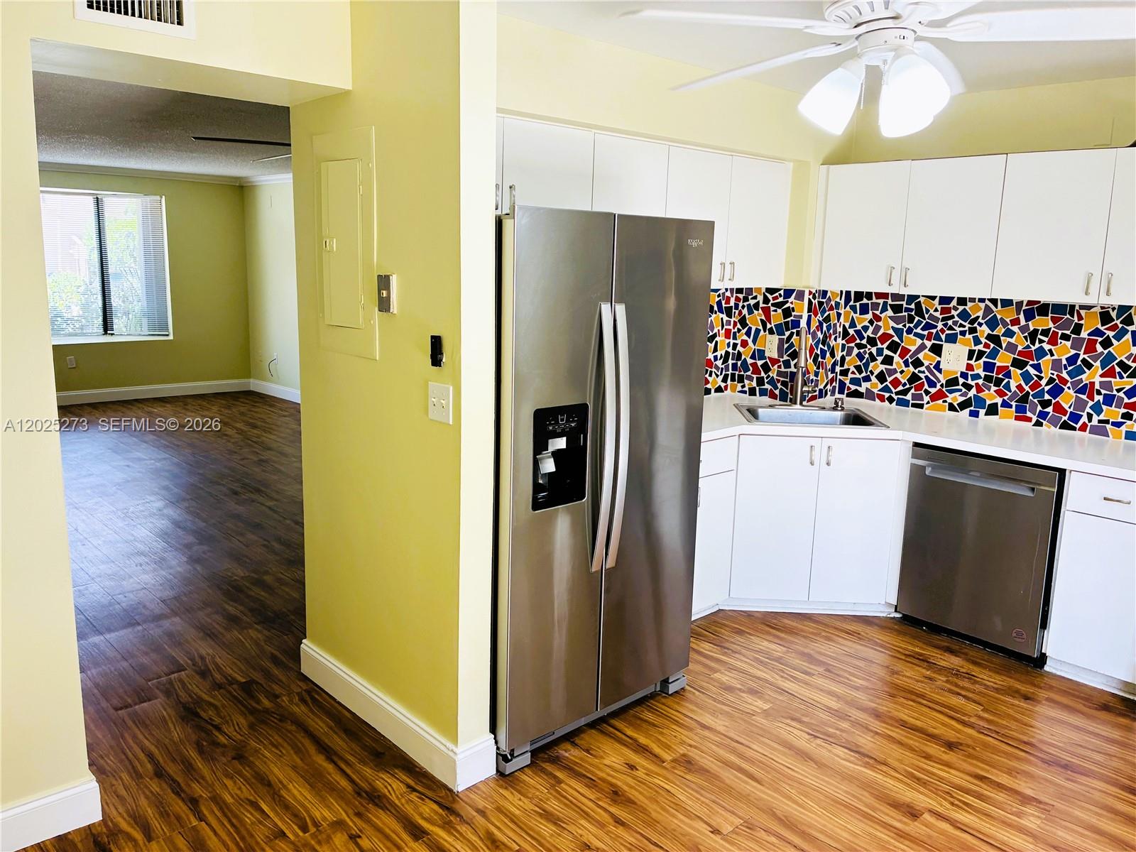 A kitchen with stainless steel appliances, white cabinets, and a colorful mosaic tile backsplash — 7796 SW 102nd Ln # 7796, Miami FL 33156, MIAMI, FL
