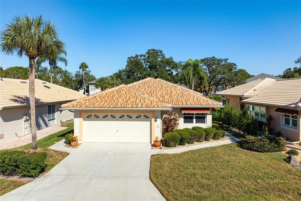 A single-story house with a tiled roof, two-car garage, and a concrete driveway — 4310 TURNBERRY COURT, BRADENTON, FL
