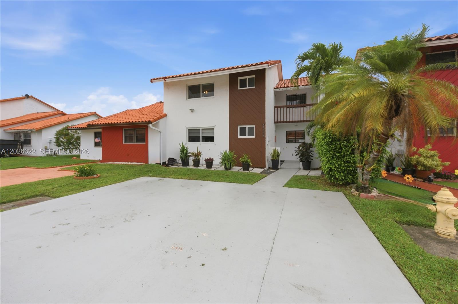 A two-story residential building with white and brown siding, a tiled roof, and a driveway — 13523 SW 59th Ter, Miami FL 33183, MIAMI, FL