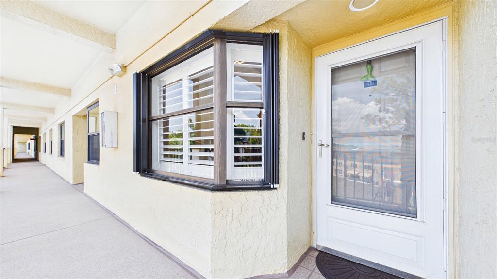 An exterior view of a building corridor featuring a bay window and a white door — 5775 PARK STREET N UNIT 410, ST PETERSBURG, FL