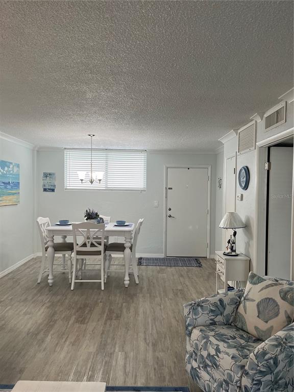 A dining area with a white table and chairs sits next to a front door — 2727 N ATLANTIC AVENUE UNIT 414, DAYTONA BEACH, FL