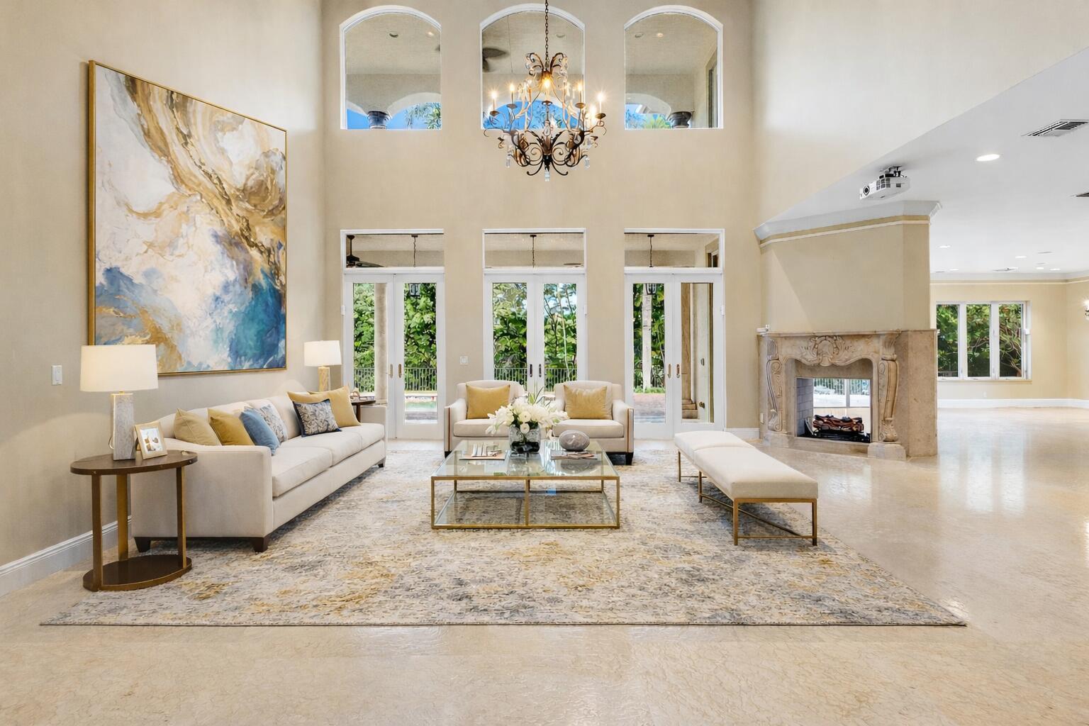 A spacious living room features high ceilings, a stone fireplace, and large glass doors — 4255 Gleneagles Drive, Boynton Beach FL 33436, BOYNTON BEACH, FL