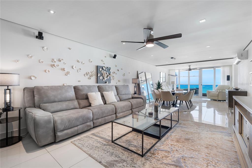 A living room features a grey sofa, glass coffee table, and ocean views through sliding doors — 5575 AVENIDA ISLA VERDE UNIT 904, CAROLINA, PR