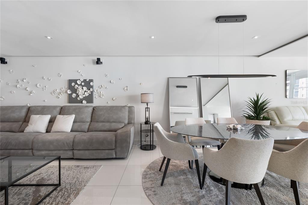 A modern living and dining area features a gray sofa, round table, and wall art — 5575 AVENIDA ISLA VERDE UNIT 904, CAROLINA, PR