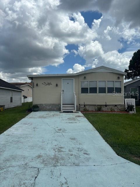 A single-story manufactured home with light siding and a light blue concrete driveway — 50989 HIGHWAY 27 UNIT 233, DAVENPORT, FL
