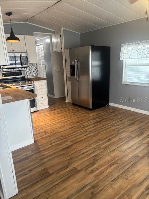A kitchen with wood-look flooring, white cabinets, stainless steel appliances, and a pendant light — 50989 HIGHWAY 27 UNIT 233, DAVENPORT, FL