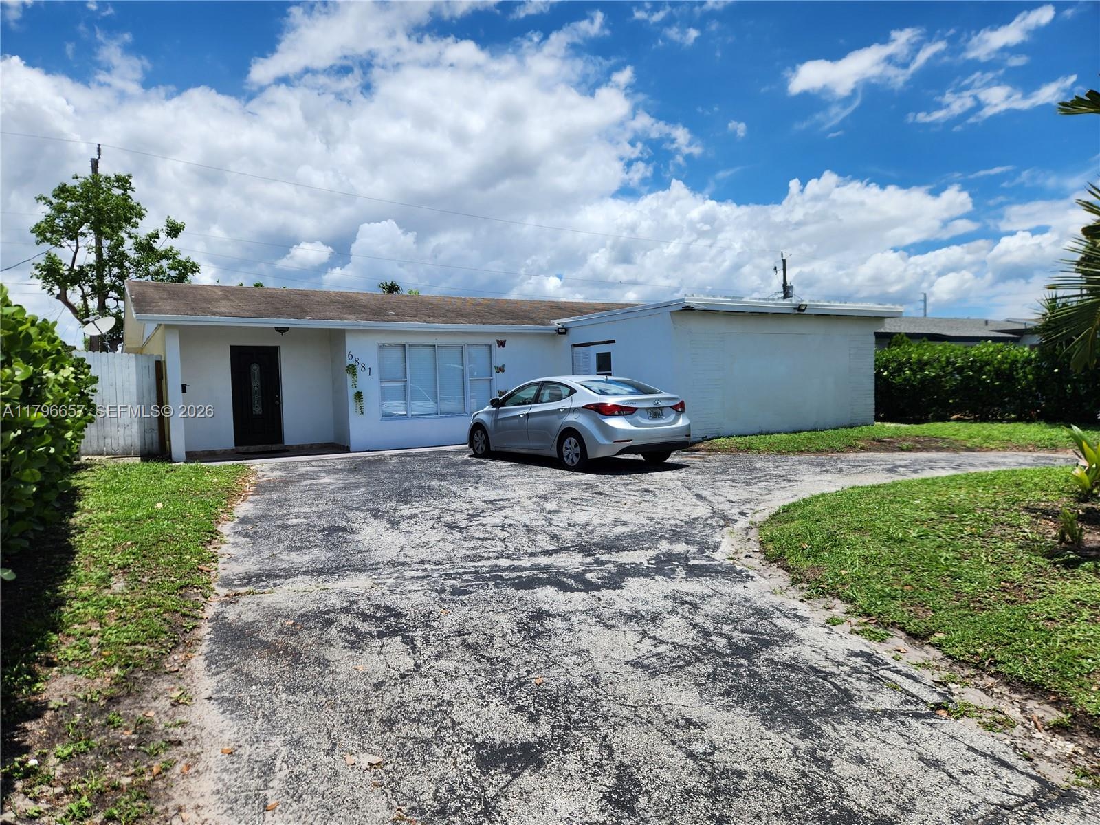 A single-story white house with a driveway and a silver car parked in front — 6881 Sheridan St, Hollywood FL 33024, HOLLYWOOD, FL