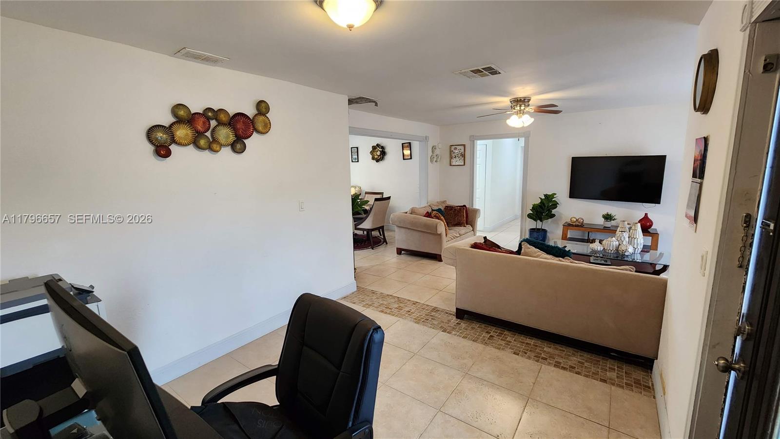 A living room and dining area feature tile flooring, neutral walls, and a ceiling fan — 6881 Sheridan St, Hollywood FL 33024, HOLLYWOOD, FL