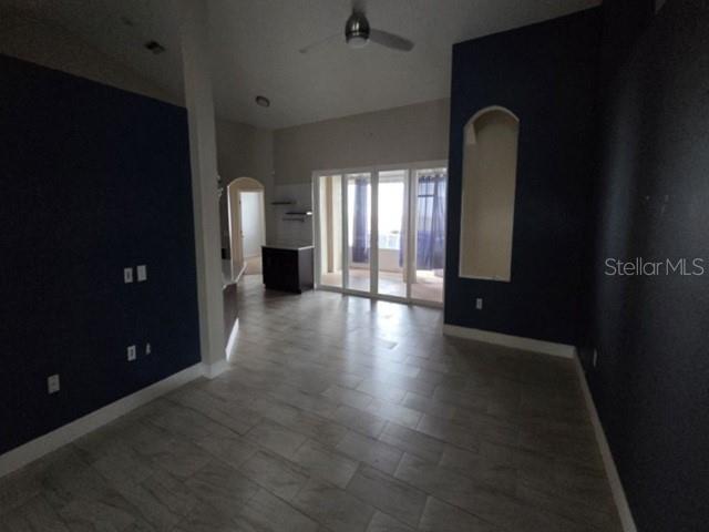 A living room with dark blue walls, tile flooring, a ceiling fan, and sliding glass doors — 4528 RIVER CLOSE BOULEVARD, VALRICO, FL