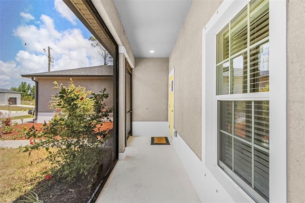 A single-story house exterior features a paved walkway leading to a light green front door — 8258 DIMSTEAD STREET, PORT CHARLOTTE, FL