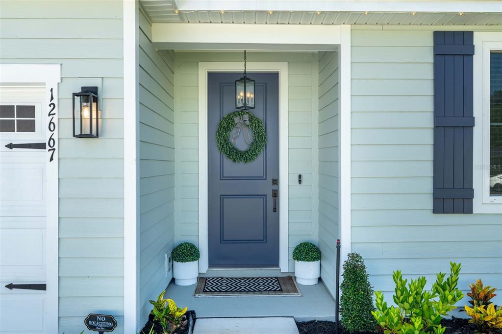 The exterior of a house features a blue front door with a wreath and sidelights — 12667 SENBAY COURT, JACKSONVILLE, FL