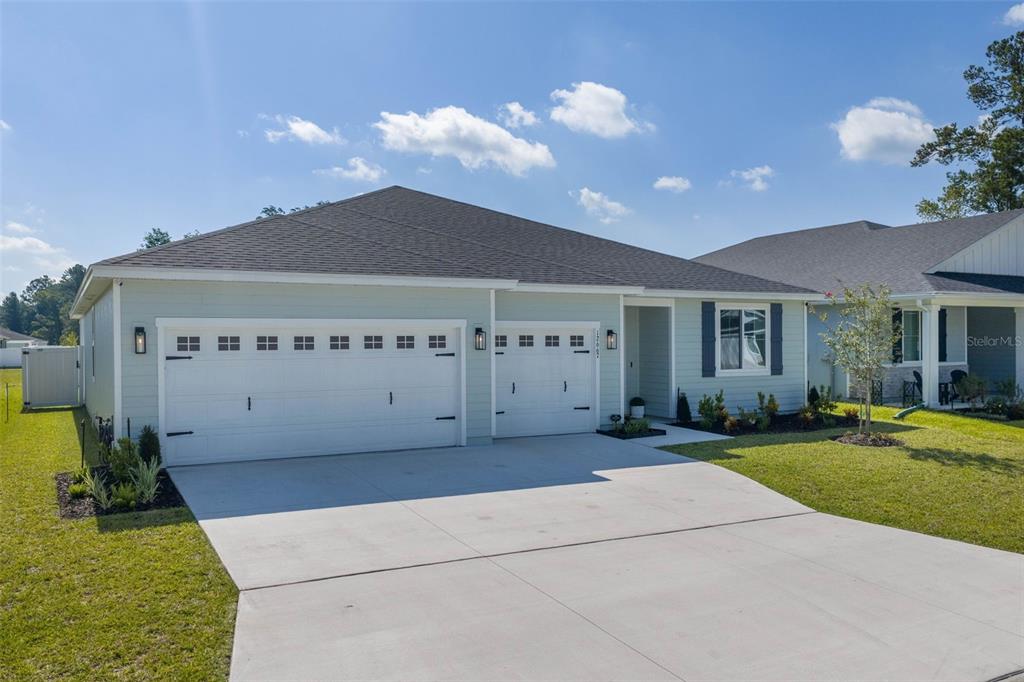 A light green single-story house with a three-car garage and a concrete driveway — 12667 SENBAY COURT, JACKSONVILLE, FL