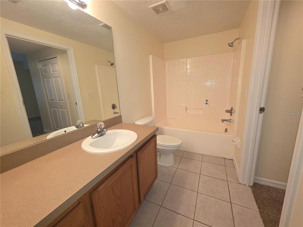 A bathroom features a vanity with a sink, a toilet, and a shower-tub combination — 6446 CYPRESSDALE DRIVE UNIT 102, RIVERVIEW, FL