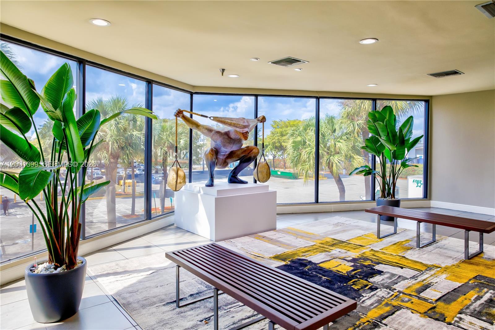 A lobby features a large sculpture, two benches, potted plants, and floor-to-ceiling windows — 2801 NW 74 AV # S07, Miami FL 33122, MIAMI, FL