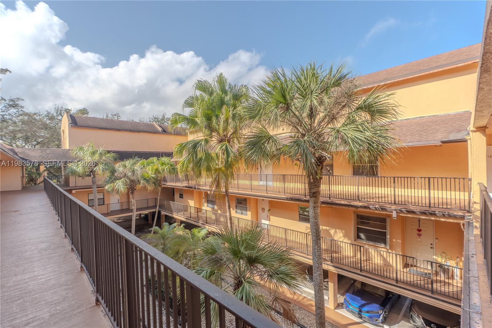 An exterior view of a multi-story apartment complex with balconies overlooking a central courtyard — 430 Commodore Dr # 314, Plantation FL 33325, PLANTATION, FL
