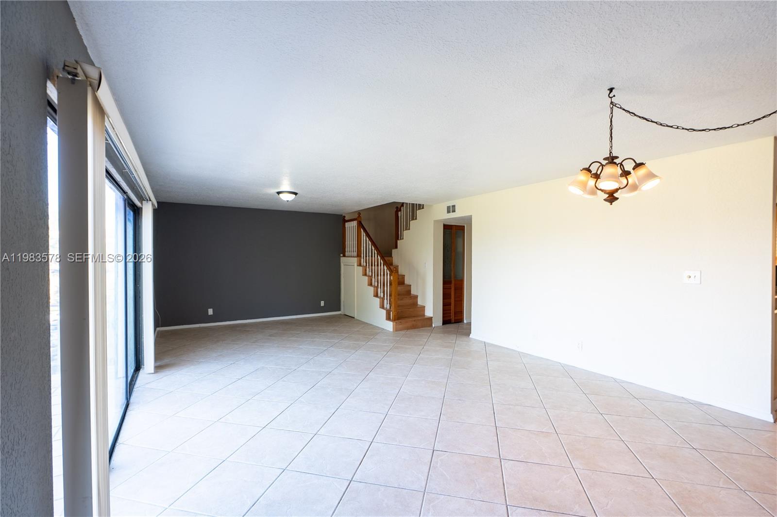 An open living area features a staircase, tile flooring, and a dark accent wall — 430 Commodore Dr # 314, Plantation FL 33325, PLANTATION, FL