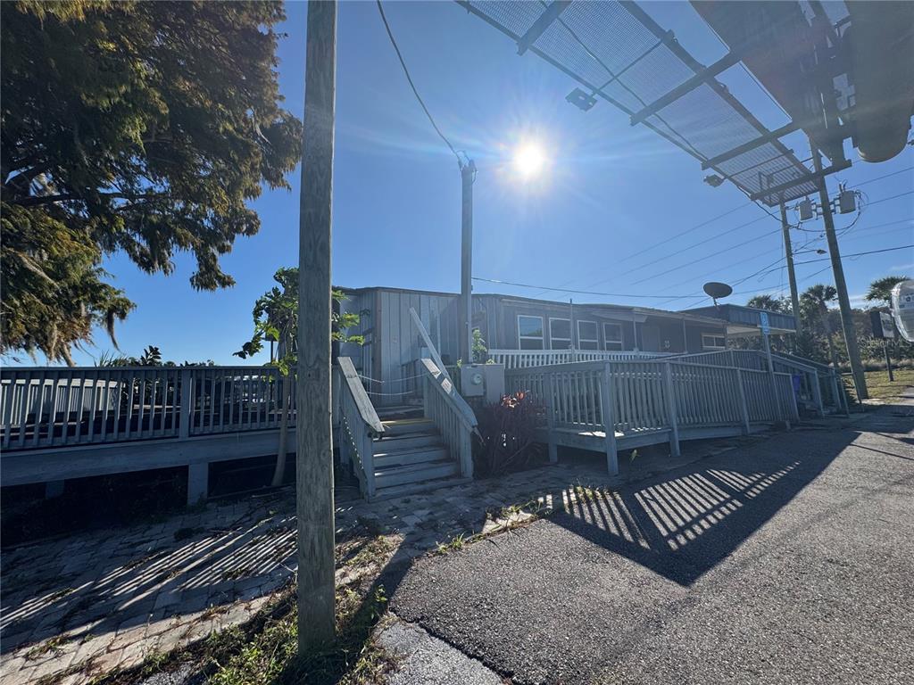 A single-story building with a wooden deck and wheelchair ramp sits beside a paved road — 1050 W BURLEIGH BOULEVARD, TAVARES, FL