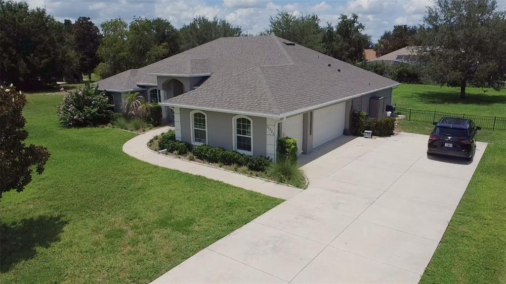 An aerial view shows a single-story house with a gray roof, stucco exterior, and driveway — 11321 OSWALT ROAD, CLERMONT, FL