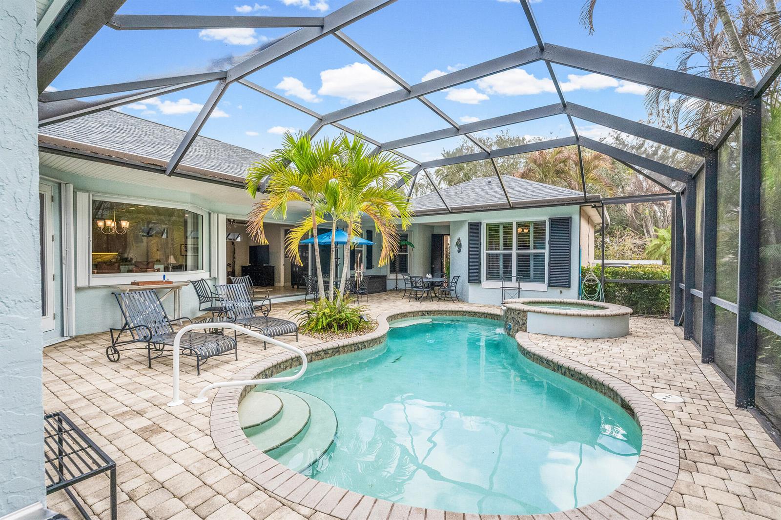 A screened-in patio features a swimming pool, a hot tub, and a palm tree — 224 Oak Hammock Circle SW, Vero Beach FL 32962, VERO BEACH, FL