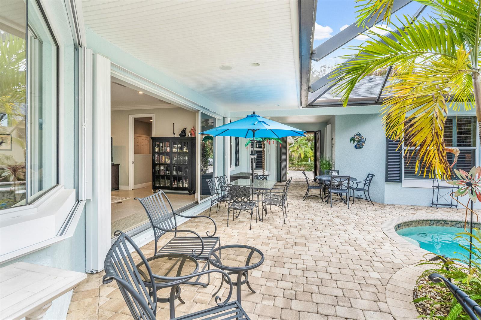A covered patio features a pool, outdoor dining area, and sliding glass doors to the interior — 224 Oak Hammock Circle SW, Vero Beach FL 32962, VERO BEACH, FL