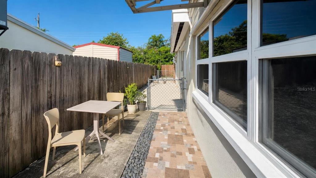 A patio area features a small table, two chairs, a wooden fence, and tiled flooring — 2311 N 58TH TERRACE, HOLLYWOOD, FL