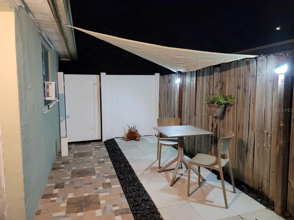 A small outdoor patio features a table, two chairs, a shade sail, and a fence — 2311 N 58TH TERRACE, HOLLYWOOD, FL