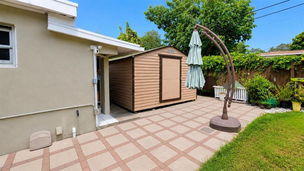 A tan storage shed sits on a paved patio next to a house exterior — 2311 N 58TH TERRACE, HOLLYWOOD, FL