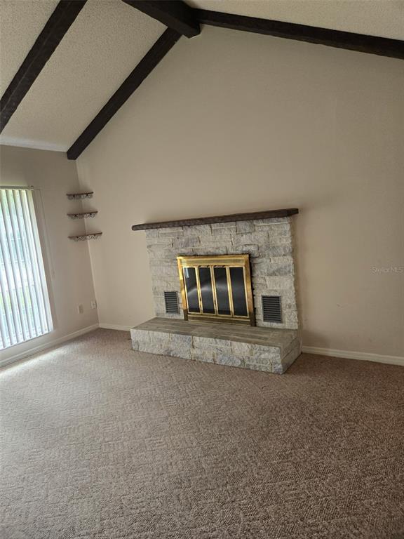 A living room features a vaulted ceiling with exposed beams and a stone fireplace — 4343 NW 80TH AVENUE UNIT 2, OCALA, FL