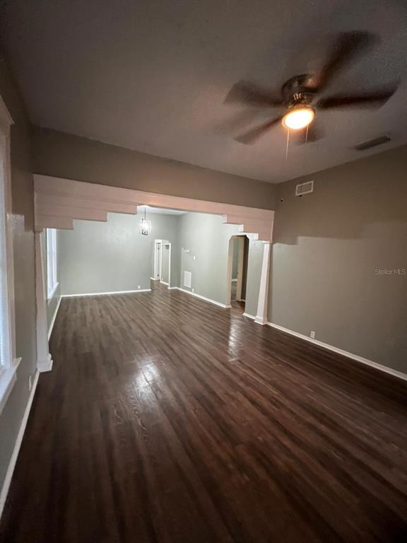 An interior view of a room with dark wood-look flooring and a ceiling fan — 3021 SANCHEZ STREET, TAMPA, FL