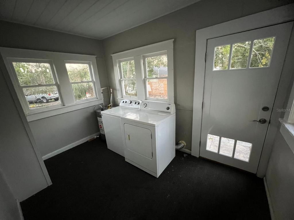 A laundry room features a white washer and dryer, gray walls, and a glass-paneled door — 3021 SANCHEZ STREET, TAMPA, FL