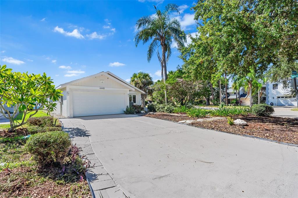 A single-story house with a white garage door and a concrete driveway under a blue sky — 4448 MARINE PARKWAY, NEW PORT RICHEY, FL