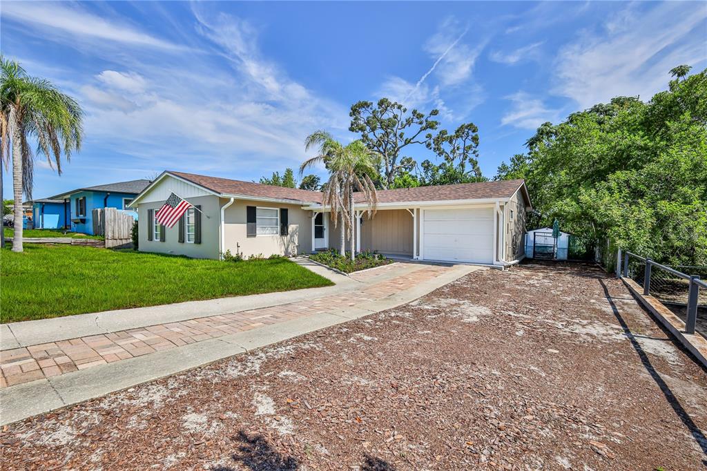 A single-story house with a paved driveway, a garage, and a front lawn — 7163 FIRESIDE STREET, SPRING HILL, FL