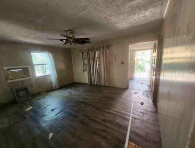An interior view of a living room with wood-look flooring, a ceiling fan, and curtains — 1127 ROBINSON AVENUE, APOPKA, FL