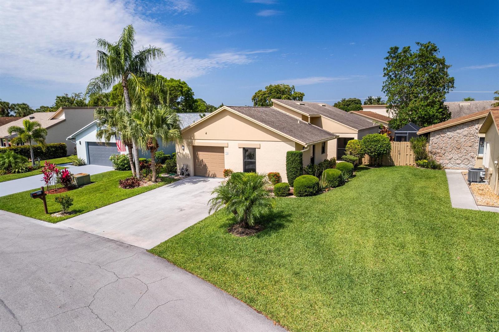 An exterior view of a beige single-story house with a garage and a green lawn — 786 NW 31st Avenue, Delray Beach FL 33445, DELRAY BEACH, FL